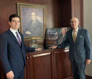 Image of Jake and Michael Glasser in front of Bernard and Richard Glassers' portrait